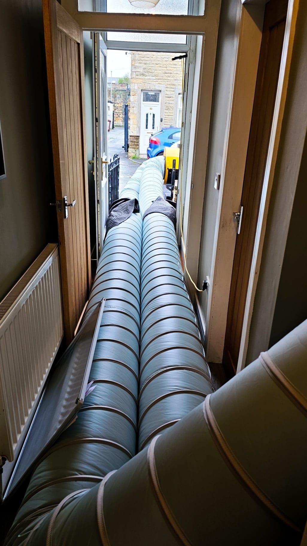 Heat treatment ducting running through the hallway of a terraced house during professional bed bug treatment