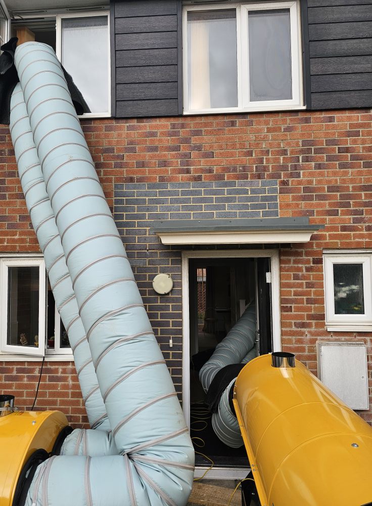Industrial heat treatment heater with ducting connected to upstairs windows of a brick terraced property