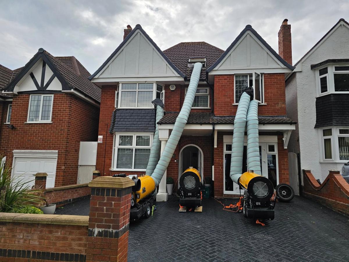 Professional bed bug heat treatment equipment setup outside a residential property with industrial heaters and ducting